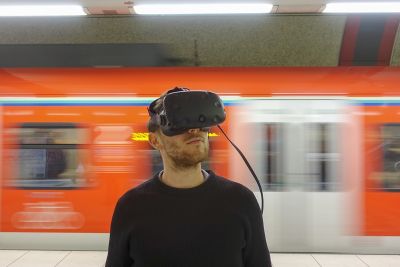 Ein Mann mit der VR-Brille in der S-Bahn-Station